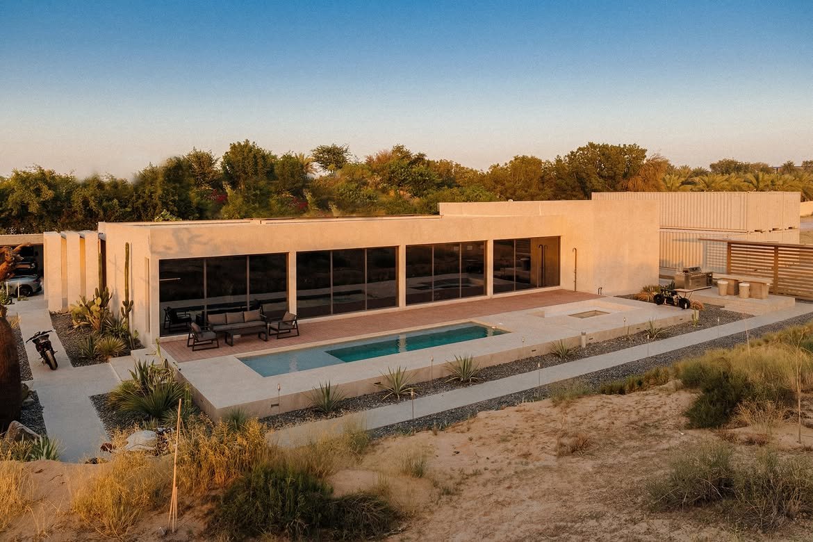 The house seen from above at first light, the pool set into the desert