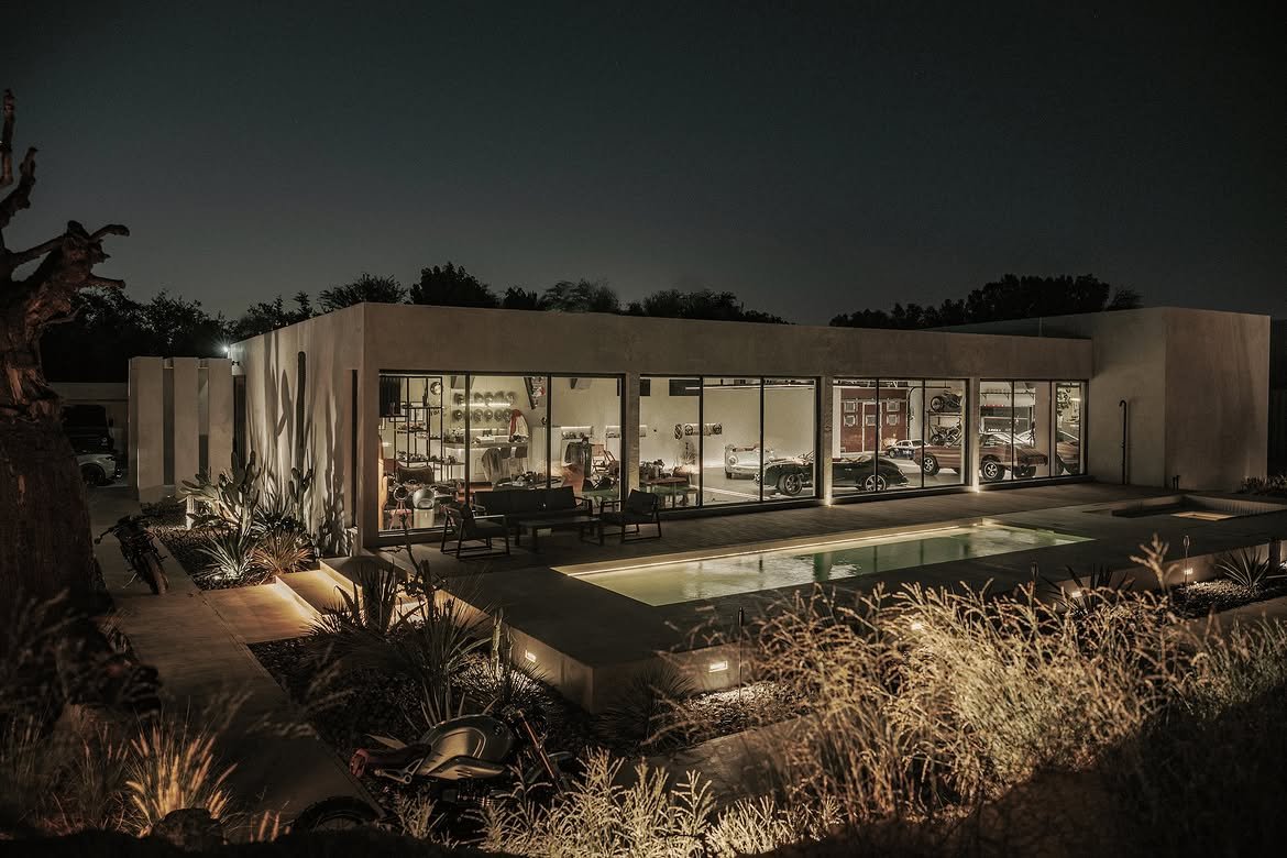 The courtyard after dark, lit windows reflected in the pool